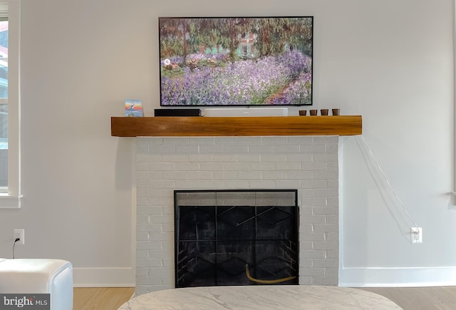 interior details featuring a brick fireplace and baseboards