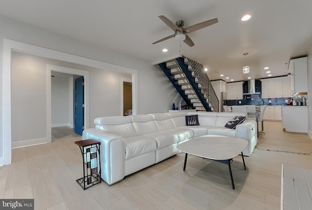 living room featuring stairs, ceiling fan, light wood-type flooring, and recessed lighting