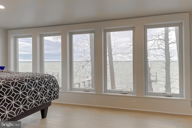 interior space with a water view, baseboards, and wood finished floors