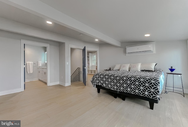 bedroom with recessed lighting, wood finished floors, ensuite bath, and a wall mounted AC