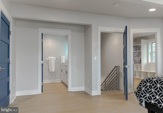 interior space featuring light wood-style floors, recessed lighting, baseboards, and an upstairs landing