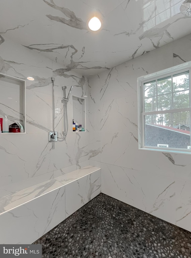 full bathroom with stone wall and a marble finish shower