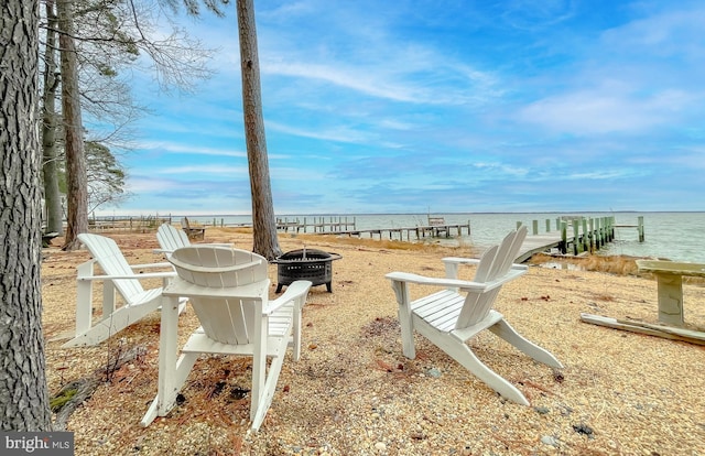 view of community featuring a water view and a fire pit