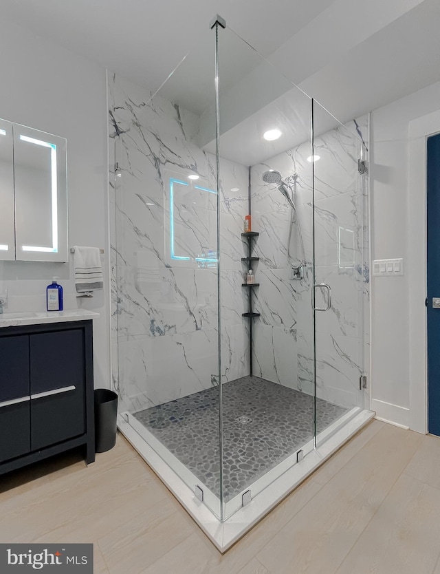 full bathroom with vanity and a marble finish shower