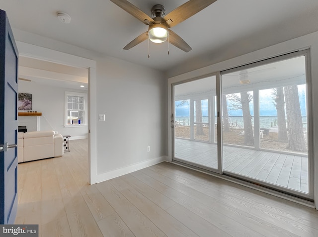 unfurnished room featuring light wood-type flooring, ceiling fan, and baseboards