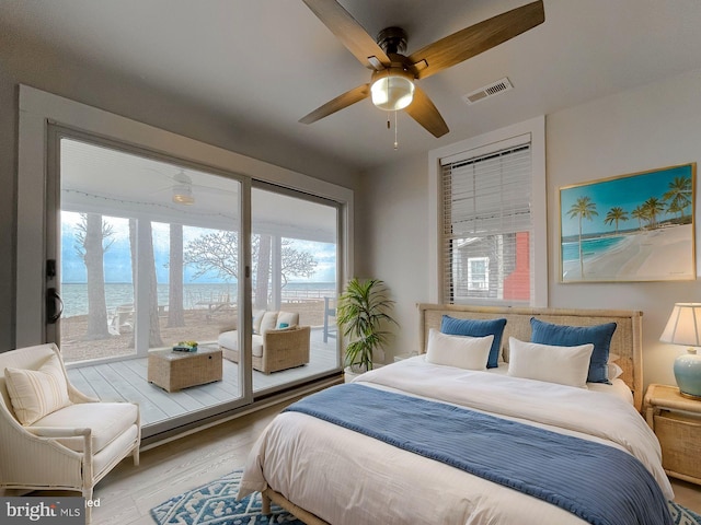 bedroom featuring access to exterior, visible vents, and wood finished floors