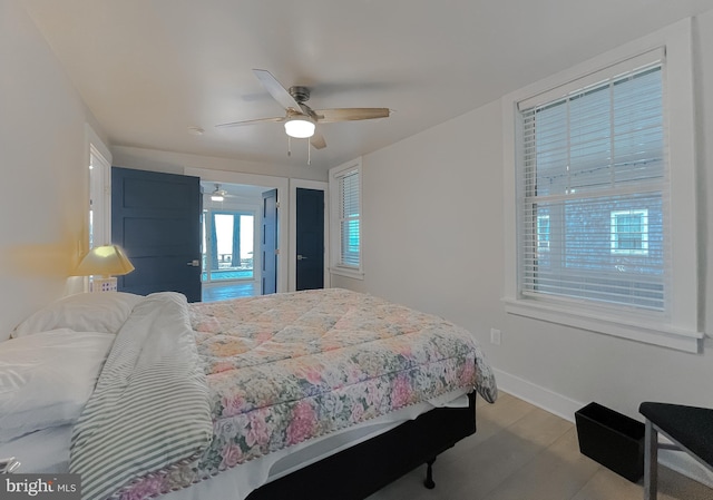 bedroom with ceiling fan, baseboards, and wood finished floors