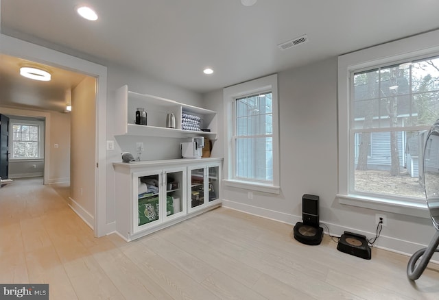 interior space featuring light wood-type flooring, visible vents, baseboards, and recessed lighting