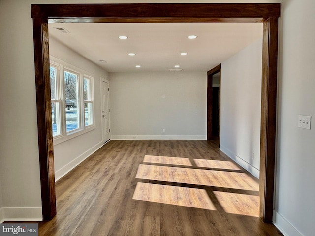 empty room featuring visible vents, recessed lighting, light wood-style flooring, and baseboards