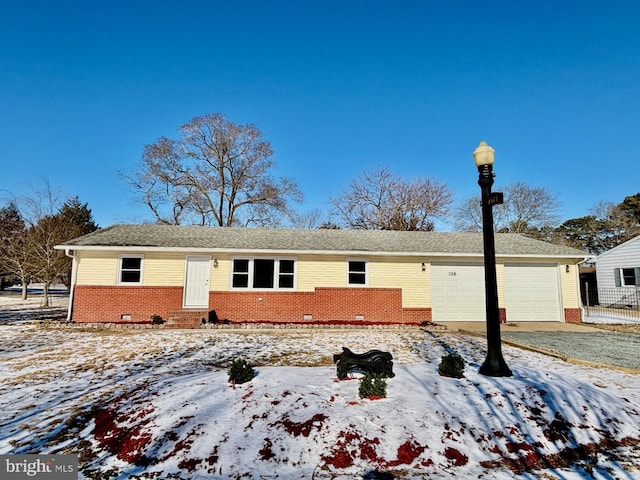 view of front of house with brick siding, entry steps, crawl space, a garage, and driveway