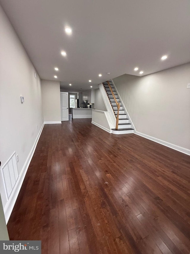 unfurnished living room featuring stairs, visible vents, dark wood finished floors, and recessed lighting