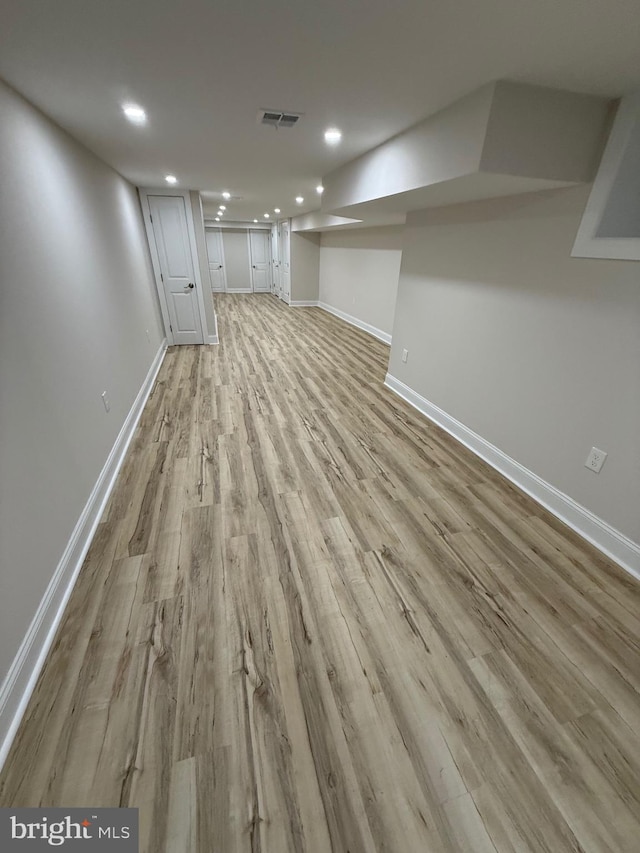 finished basement featuring recessed lighting, light wood-type flooring, visible vents, and baseboards