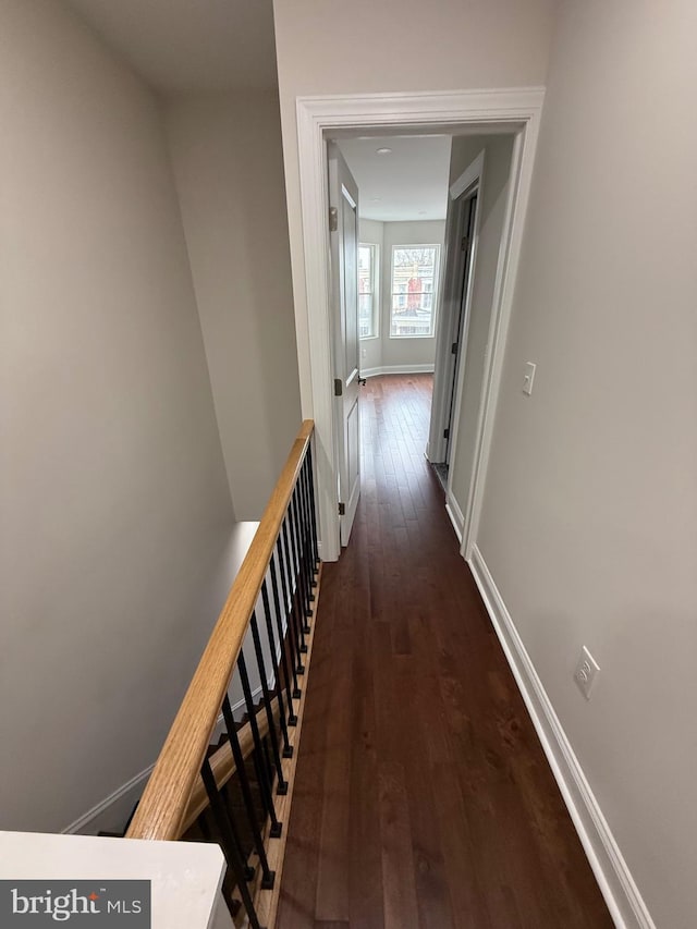 hallway with dark wood-style floors and baseboards