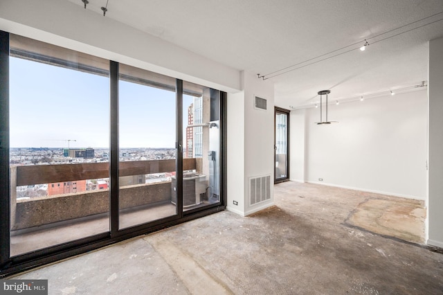 unfurnished room with visible vents, plenty of natural light, and unfinished concrete floors