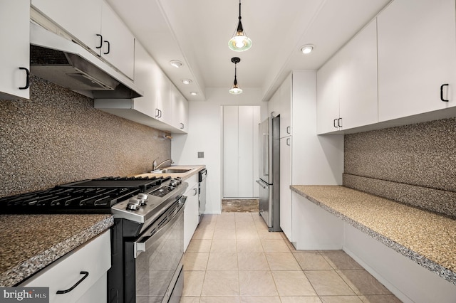 kitchen with appliances with stainless steel finishes, decorative light fixtures, under cabinet range hood, white cabinetry, and a sink