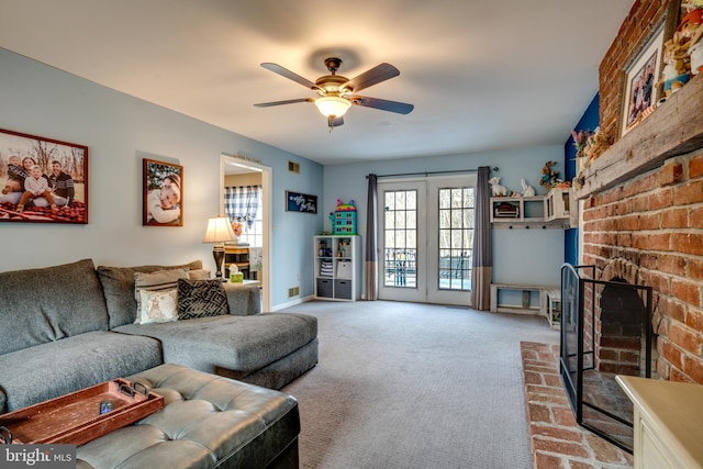 living area with baseboards, a fireplace, a ceiling fan, and light colored carpet