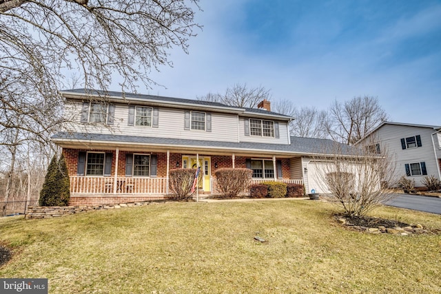 traditional-style home featuring covered porch, brick siding, driveway, a front lawn, and a chimney