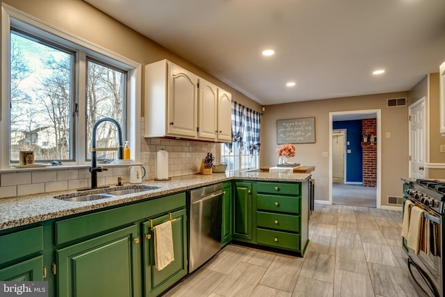 kitchen featuring a sink, white cabinets, stainless steel dishwasher, gas range, and green cabinetry