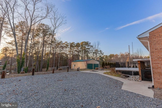 view of yard featuring a deck, an outbuilding, and a patio