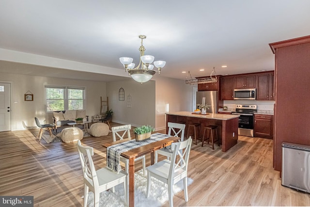 dining space featuring baseboards, recessed lighting, light wood-type flooring, and a chandelier