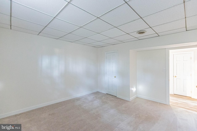 spare room with visible vents, a paneled ceiling, carpet, and baseboards