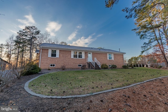 back of property featuring brick siding and a lawn