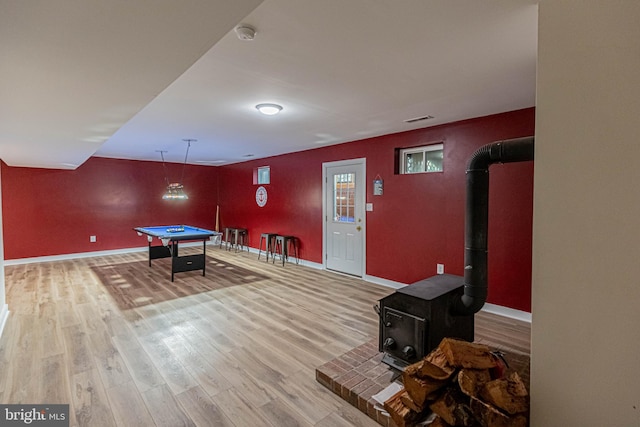 rec room featuring billiards, wood finished floors, visible vents, baseboards, and a wood stove