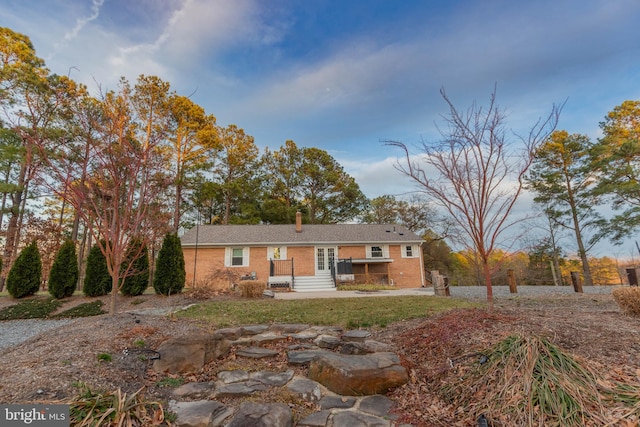 ranch-style home with brick siding and a chimney