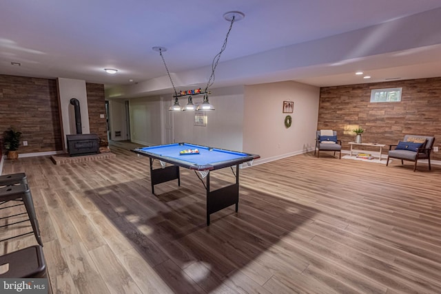 playroom with billiards, wood finished floors, recessed lighting, baseboards, and a wood stove