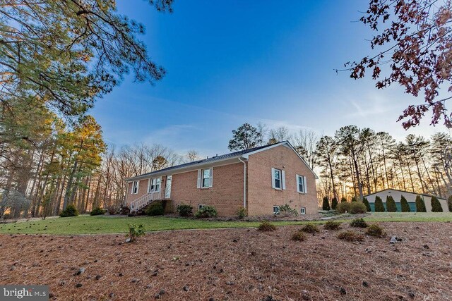 view of side of property with a yard and brick siding