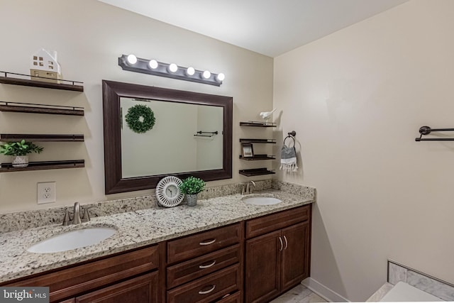 bathroom with a sink, baseboards, and double vanity