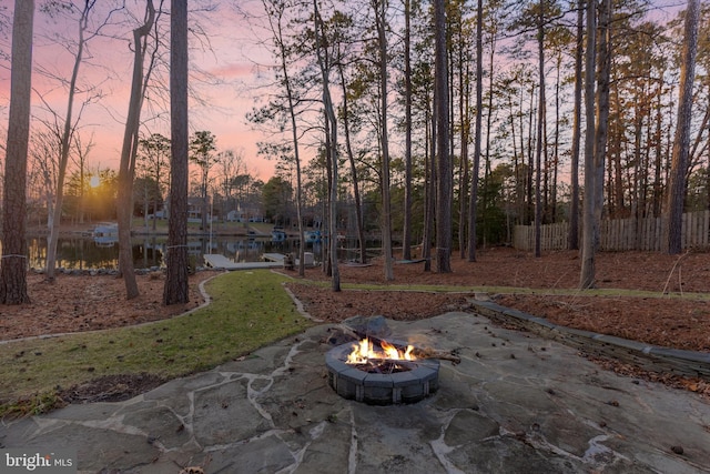 patio terrace at dusk with an outdoor fire pit and fence