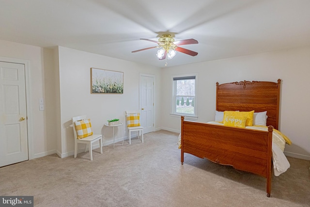 bedroom featuring baseboards, light colored carpet, and a ceiling fan