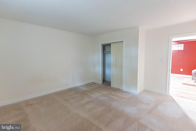 unfurnished bedroom featuring carpet, baseboards, and a closet