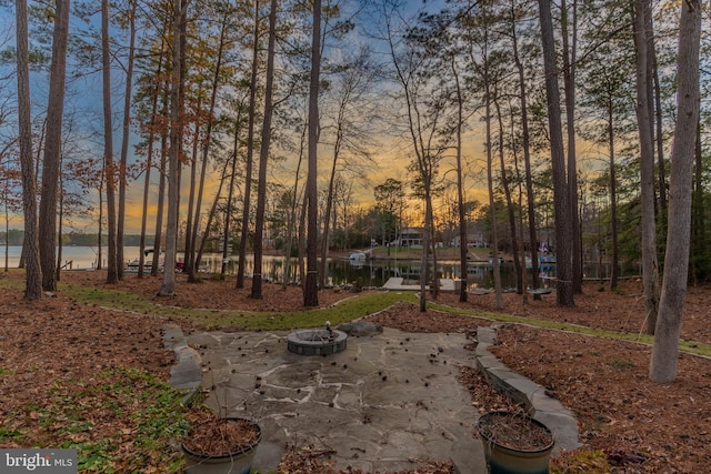 view of yard with an outdoor fire pit and a water view