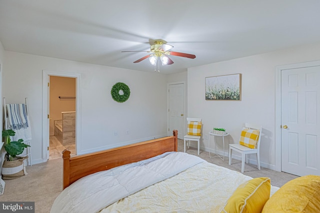 carpeted bedroom with a ceiling fan, baseboards, and ensuite bathroom