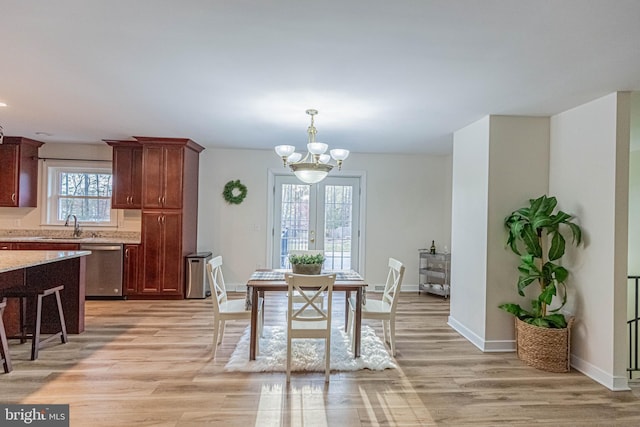 dining area featuring a notable chandelier, light wood-style floors, and baseboards