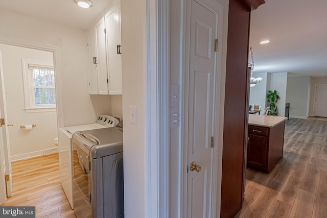 washroom with baseboards, recessed lighting, light wood-style flooring, cabinet space, and independent washer and dryer