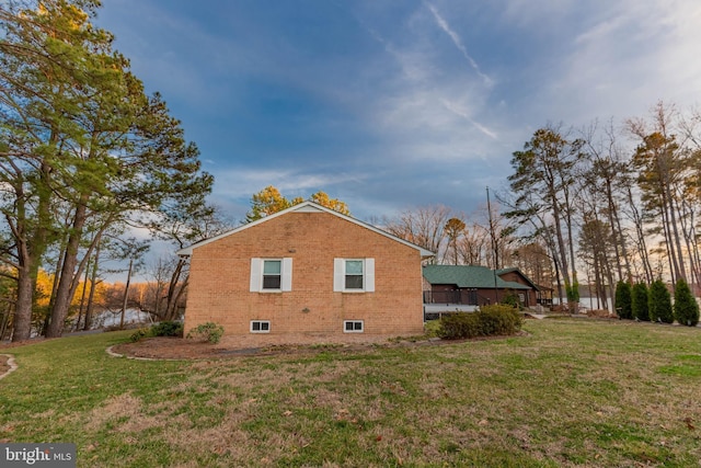 view of side of home featuring a yard and brick siding