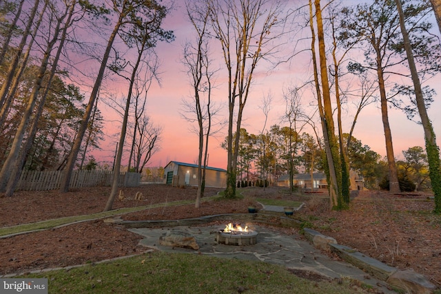 view of yard featuring an outdoor fire pit and fence