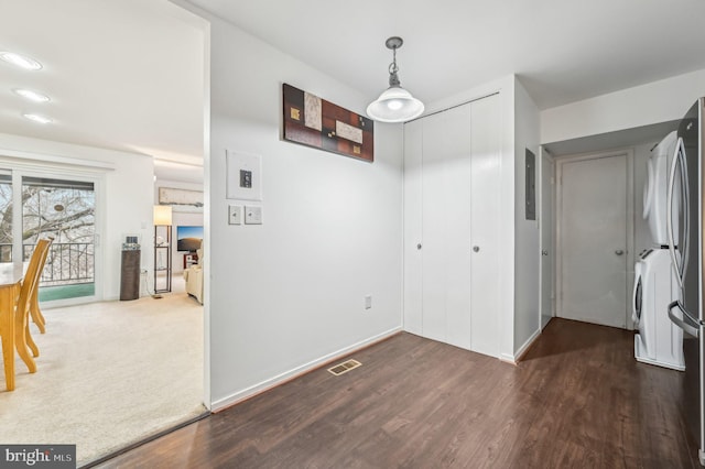 unfurnished dining area with washer / dryer, dark wood-style flooring, visible vents, and baseboards