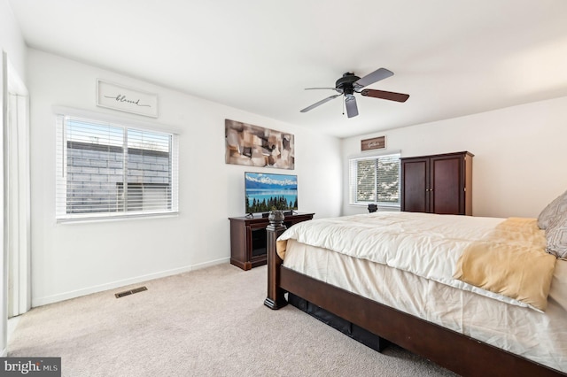 bedroom featuring baseboards, visible vents, a ceiling fan, and light colored carpet