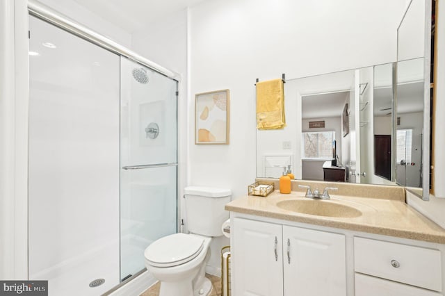 bathroom with toilet, a stall shower, and vanity