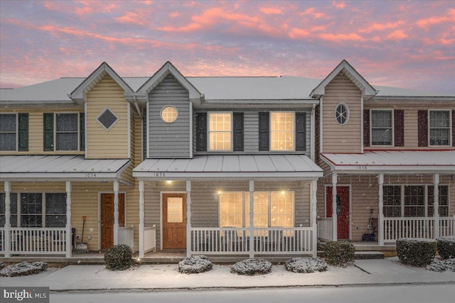 townhome / multi-family property featuring a standing seam roof, metal roof, and a porch