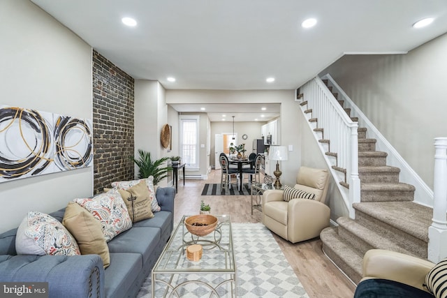 living room featuring light wood-style floors, stairway, and recessed lighting