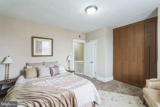 bedroom featuring baseboards, a closet, and light colored carpet