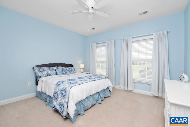 bedroom with a ceiling fan, visible vents, light carpet, and baseboards