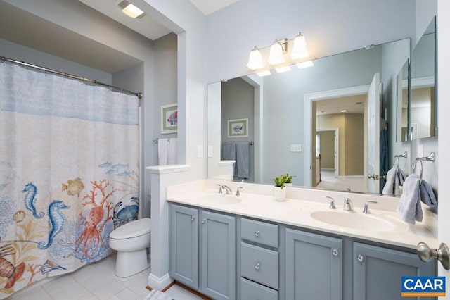 bathroom with tile patterned floors, a sink, toilet, and double vanity