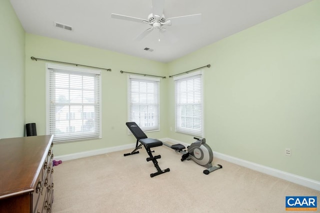 workout area featuring light carpet, visible vents, and baseboards