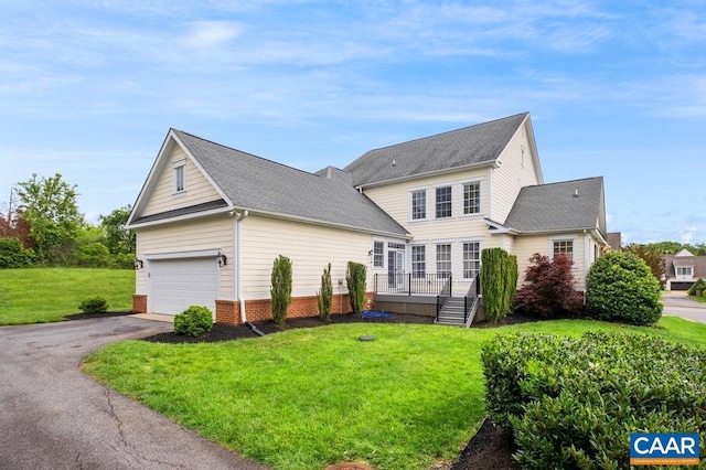 view of front of house featuring a garage, a front yard, and driveway